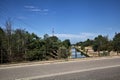 Diversionary channel bordered by trees seen from a bridge on a summer day