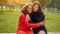 Diversity and feminity concept. Happy smiling Confident young mixed race women sitting bench park outdoor Royalty Free Stock Photo