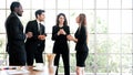 Diversity group of businesspeople strictly dressed in the suits standing meeting by office window. African and Caucasian white Royalty Free Stock Photo