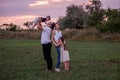 Diversity happy family plays in field at sunset. Young father lifting toddler high in the air Royalty Free Stock Photo