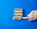 Diversity Inclusion Belonging Equity symbol. Concept words Diversity Inclusion Belonging Equity on wooden blocks. Businessman hand Royalty Free Stock Photo