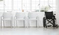 Diversity, inclusive and a row of white chairs with a black wheelchair in a waiting room in the hospital. Different Royalty Free Stock Photo