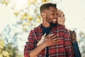 Diversity, love and couple hug in nature for relax summer holiday, outdoor freedom and happy quality time. African man Royalty Free Stock Photo