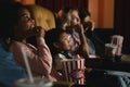 Diversity people children and young people having fun watching movie and eating popcorn in cinema theater