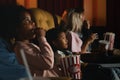 Diversity people children and young people having fun watching movie and eating popcorn in cinema theater Royalty Free Stock Photo