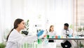 The diversity of scientists reports experimentation results to their colleagues in the research laboratory. Group of chemistry Royalty Free Stock Photo