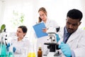 The diversity of scientists reports experimentation results to their colleagues in the research laboratory. Group of chemistry Royalty Free Stock Photo