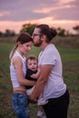 Diversity father kisses mothers forehead while holding son, concept of beautiful family connection Royalty Free Stock Photo