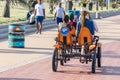 Diversity: Two black boys and two white-caucasian girls sharing a quadricycle for a ride in the beach of Durban, South africa