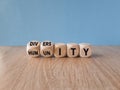 Diversty and humanity symbol. Turned wooden cubes and changes the word humanity to diversity. Beautiful blue background. Business