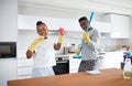 Divide and conquer. a happy young couple having fun while cleaning the kitchen at home.