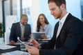 Dividing the tasks and multiplying their success. a businessman working in the boardroom with his colleagues in the Royalty Free Stock Photo