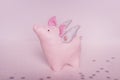 A divinely beautiful piggy angel with handmade wings stands on a white pink background with snowflakes