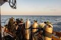 Diving gear with tanks, BCDs, regulators, weight belts assembled, on a diving boat with sea view in the background, Red Sea,