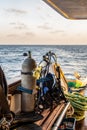 Diving gear with tanks, BCDs, regulators, weight belts assembled, on a diving boat with sea view in the background, Red Sea,