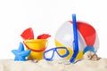 Diving mask with beach ball and toys in sand Royalty Free Stock Photo
