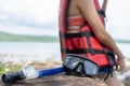 Diving mask and Snorkel Gear on beach stone with woman wearing life jacket relaxing on summer holidays. .Beach vacation snorkel Royalty Free Stock Photo