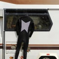 Diving suit hanging on the side of a camper parked on the beach seaside