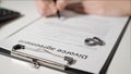 Divorce agreement. Hands of husband or wife sign divorce papers. In the foreground are titanium wedding rings.