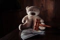 Divorce and alimony concept. Wooden gavel, dollar banknotes and teddy bear as symbol of child