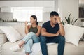 Divorce, angry or couple fight on sofa with anxiety, fear or frustrated by liar, stress or drama at home. Marriage Royalty Free Stock Photo
