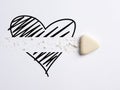 Divorce, breakup, ending love in a romantic relationship concept. White eraser erases the heart icon Royalty Free Stock Photo