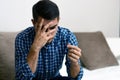 Divorce concept. Sad lonely man holding engagement ring sitting at home. Depression after a divorce. Selective focus. Royalty Free Stock Photo