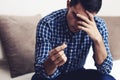 Divorce concept. Sad lonely man holding engagement ring sitting at home. Depression after a divorce. Selective focus. Royalty Free Stock Photo