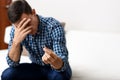 Divorce concept. Sad lonely man holding engagement ring sitting at home. Depression after a divorce. Selective focus. Royalty Free Stock Photo