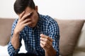 Divorce concept. Sad lonely man holding engagement ring sitting at home. Depression after a divorce. Selective focus. Royalty Free Stock Photo