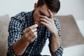 Divorce concept. Sad lonely man holding engagement ring sitting at home. Depression after a divorce. Selective focus. Royalty Free Stock Photo