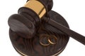 Divorce concept with wooden gavel and gold wedding rings