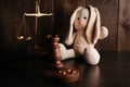 Divorce concept. Wooden gavel, rings and bunny as symbol of child. Family divorce effect on children