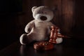 Divorce concept. Wooden gavel, rings and teddy bear as symbol of child. Family divorce effect on children