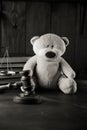 Divorce at family and alimony concept. Wooden gavel and teddy bear as symbol of child on a desk. Black and white image Royalty Free Stock Photo