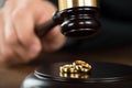 Divorce Judge Hitting Gavel On Golden Rings At Desk