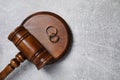 Divorce process. Wooden gavel and wedding rings on grey textured table, top view. Space for text