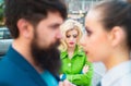 Divorce reason. Infidelity. Disloyal man walking with his girlfriend and looking amazed at another seductive girl Royalty Free Stock Photo