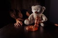 Divorce and separation concept. Wooden gavel, rings and sorrowful little boy with teddy bear