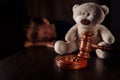 Divorce and separation concept. Wooden gavel, rings and sorrowful little boy with teddy bear. Family law