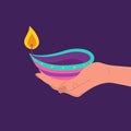 Diwali diya lamp. Female hand holding burning candle. Indian festival of lights icon. Colorful deepavali sign on purple Royalty Free Stock Photo