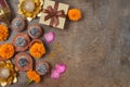 Diwali holiday concept with sweet traditional dessert, gift box and decorations on dark background. Top view, flat lay