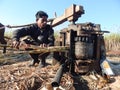 Working Rural man crushing sugarcane juice by traditional machine