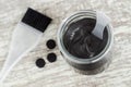 DIY charcoal face mask in a small glass jar. Homemade cosmetics.