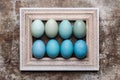 DIY dyed various shades of blue Easter eggs and vintage wooden picture frame mock up. Royalty Free Stock Photo