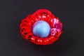Diy Easter egg basket made of red plastic cup decorated with artificial flowers black background Royalty Free Stock Photo