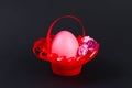 Diy Easter egg basket made of red plastic cup decorated with artificial flowers black background Royalty Free Stock Photo