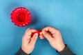 Diy Easter egg basket made of red plastic cup decorated with artificial flowers on blue background Royalty Free Stock Photo