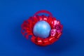 Diy Easter egg basket made of red plastic cup decorated with artificial flowers blue background Royalty Free Stock Photo