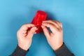 Diy Easter egg basket made of red plastic cup decorated with artificial flowers on blue background Royalty Free Stock Photo